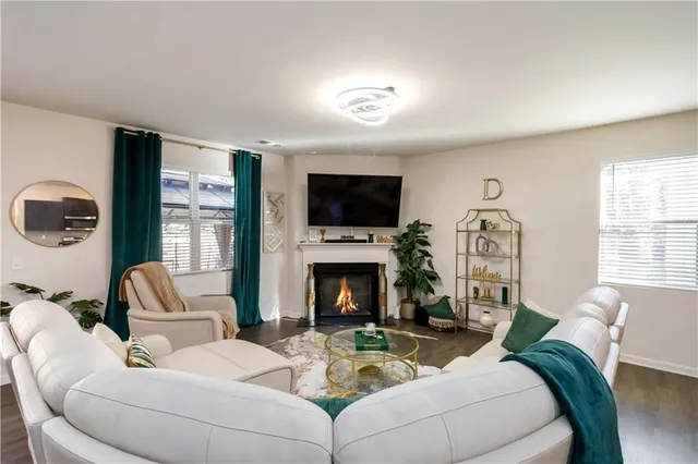 a living room with furniture a fireplace and a flat screen tv