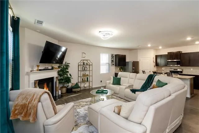 a living room with furniture a fireplace and a flat screen tv