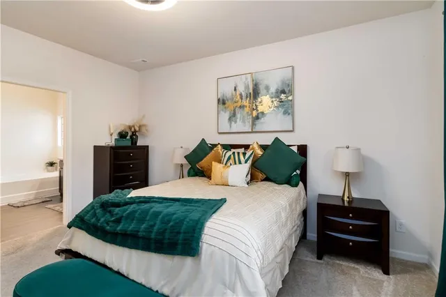 a bedroom with a bed and a lamp on dresser