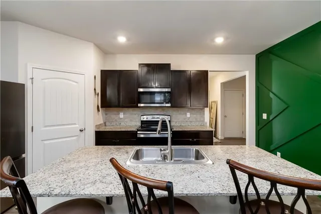 a kitchen with granite countertop cabinets and refrigerator