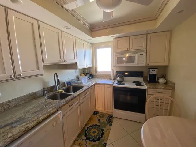 a kitchen with stainless steel appliances a stove a sink a cabinets and chairs