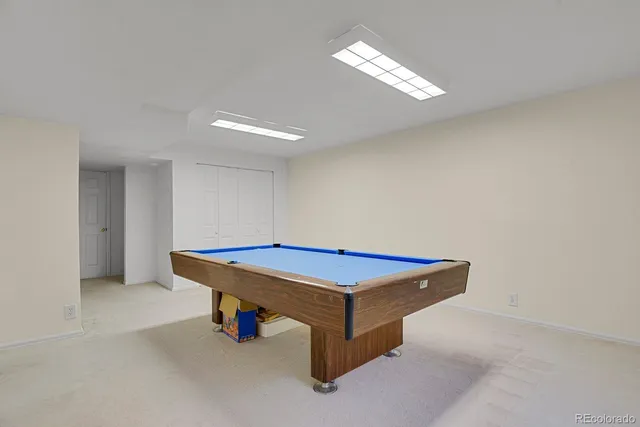 a room with pool table and windows