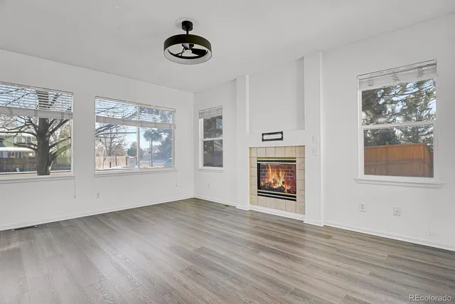 a view of an empty room with window and wooden floor