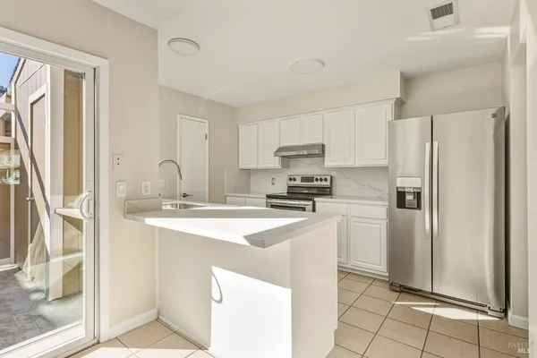 a kitchen with stainless steel appliances a refrigerator sink and cabinets