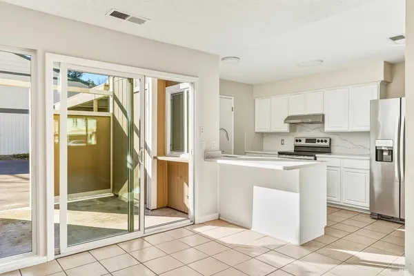 a kitchen with stainless steel appliances granite countertop a refrigerator and a stove top oven