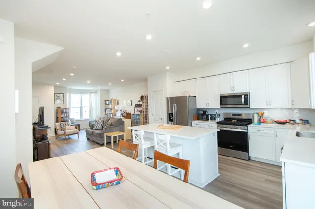 a large white kitchen with lots of counter space and stainless steel appliances