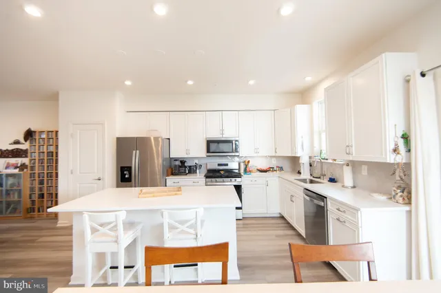a large kitchen with a large window and stainless steel appliances