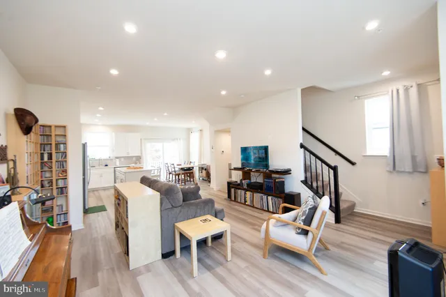 a living room with lots of furniture wooden floor and a table