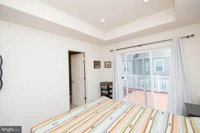 a spacious bedroom with a bed and wooden floor