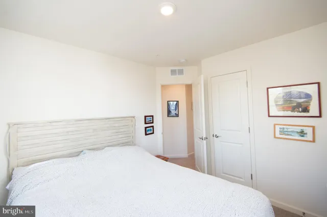 a bedroom with a bed and painting on the wall