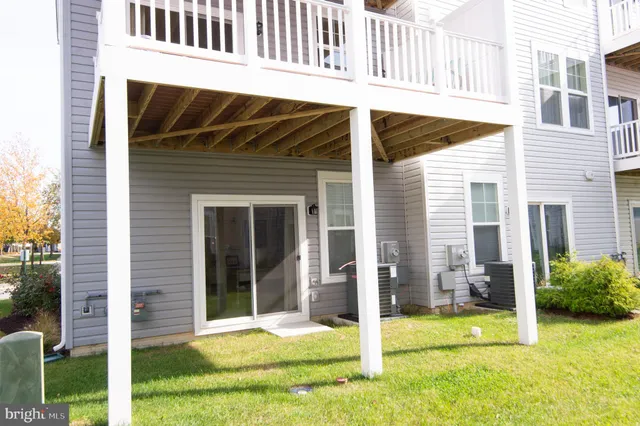a view of a house with a small yard and wooden floor and fence