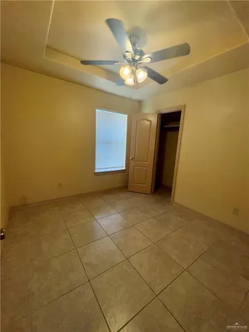 a view of an empty room with a chandelier fan