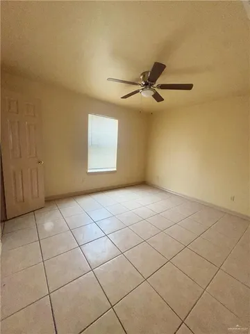 a view of an empty room and a chandelier fan