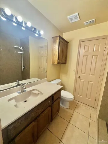a bathroom with a sink a toilet a mirror and vanity