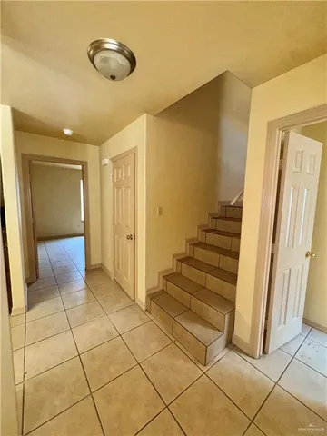 a view of a hallway with wooden floor and cabinet