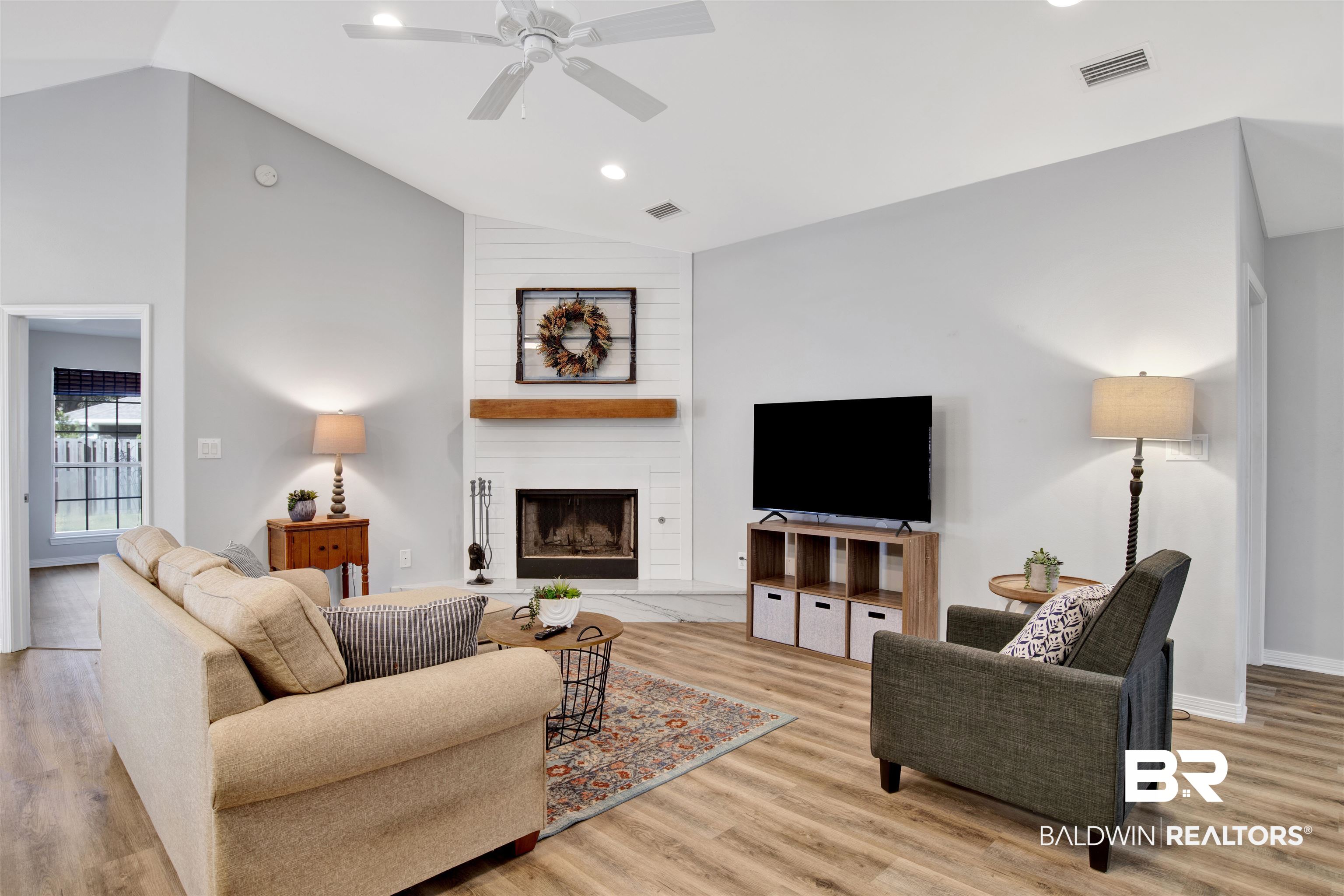 7145 Raintree Lane Gulf Shores, AL 36542 - Photo 5 of 25 Living room featuring a fireplace, light hardwood / wood-style flooring, ceiling fan, and lofted ceiling