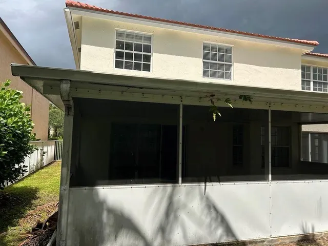 front view of house with a yard and potted plants
