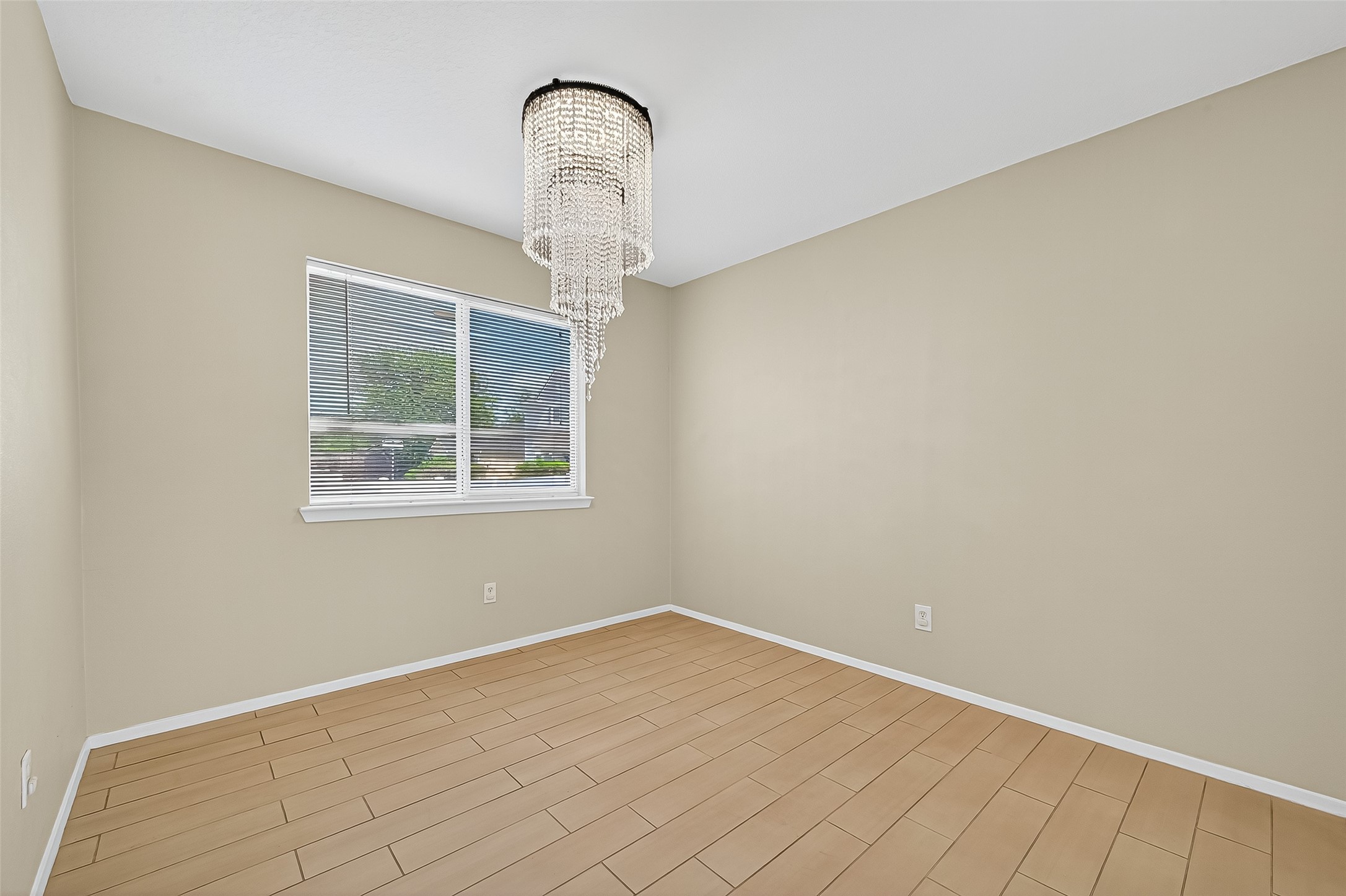 6343 Settlers Square Lane Katy, TX 77449 - Photo 14 of 41 an empty room with a chandelier fan and wooden floor