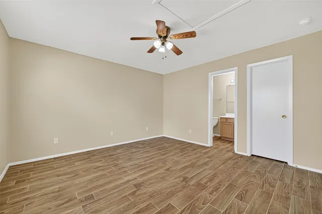 wooden floor in an empty room with a ceiling fan