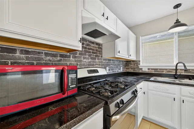 a kitchen with stainless steel appliances granite countertop a stove and a sink