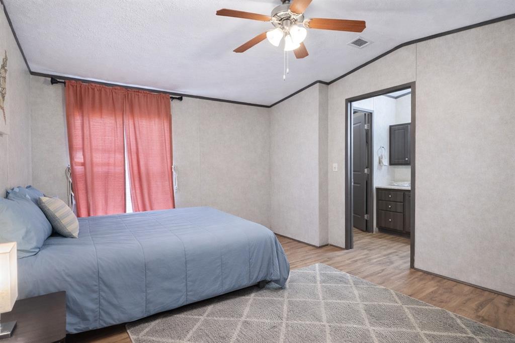 112 Rising Star Quitman, TX 75783 - Photo 23 of 39 a bedroom with a large bed and a chandelier