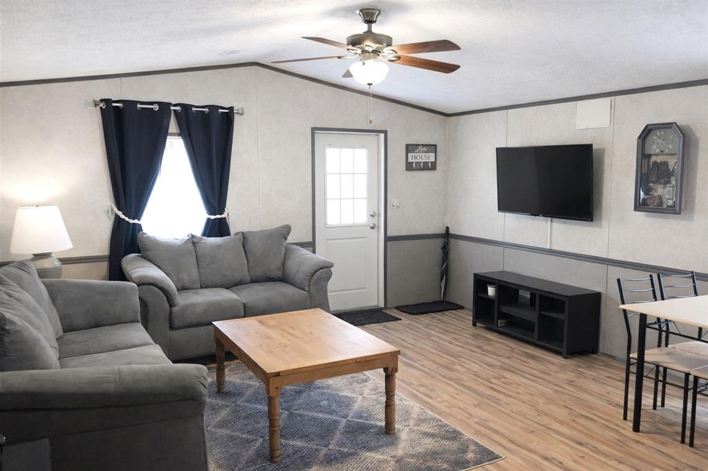 112 Rising Star Quitman, TX 75783 - Photo 8 of 39 a living room with furniture a flat screen tv and a fireplace
