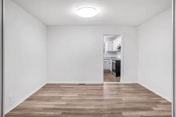 a view of empty room with wooden floor