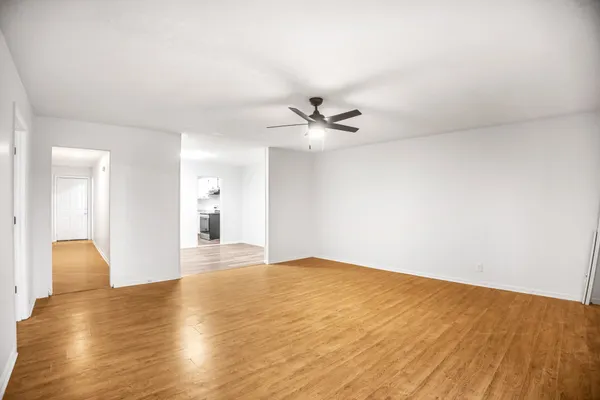 a view of an empty room with wooden floor