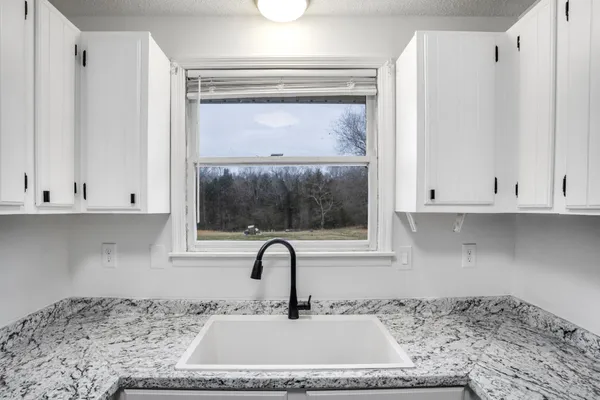 a kitchen with granite countertop a sink and a window