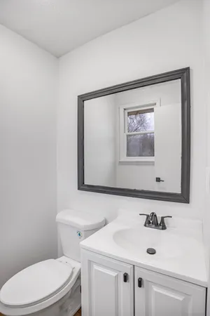 a bathroom with a sink mirror and toilet