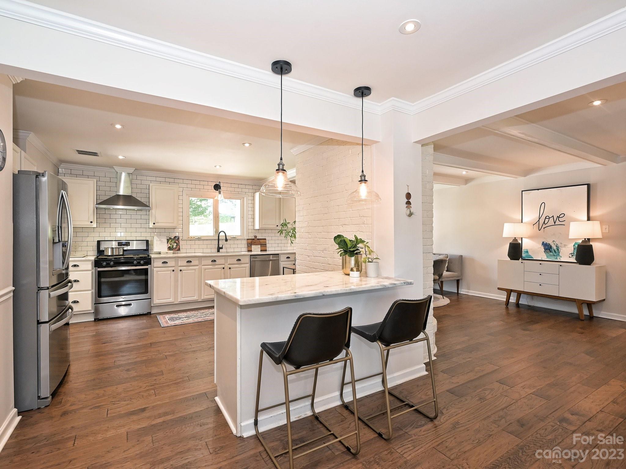 101 Scofield Road Charlotte, NC 28209 - Photo 6 of 26 a kitchen with stainless steel appliances kitchen island granite countertop a refrigerator a stove a sink dishwasher and a dining table with wooden floor