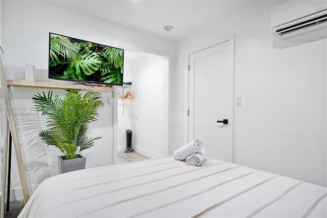 a bedroom with a bed and a potted plant