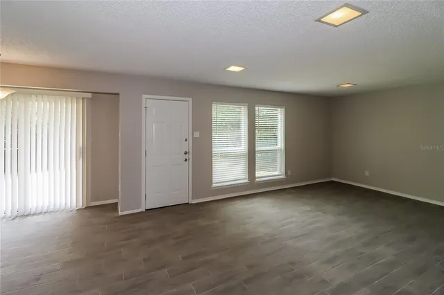 an empty room with windows and closet