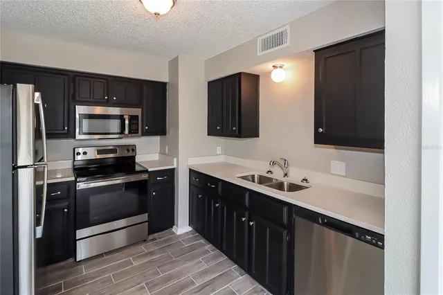 a kitchen with a sink and stainless steel appliances