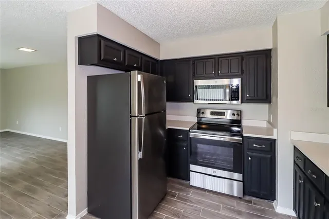a kitchen with stainless steel appliances granite countertop a refrigerator and a stove