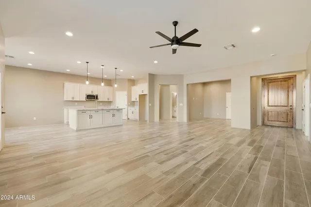 a view of a hallway with wooden floor and a bathroom