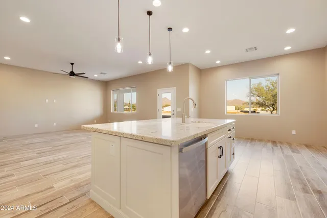 a bathroom with a granite countertop double vanity sink mirror and shower