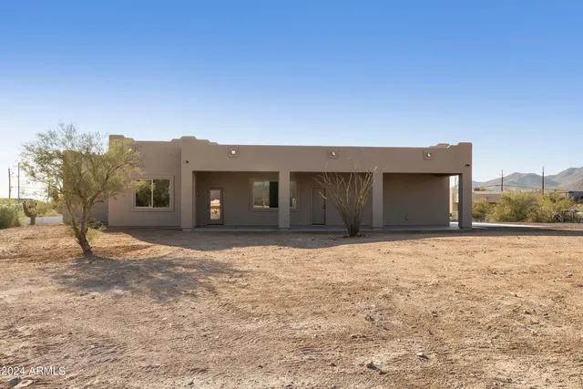 a view of a house with a garden and sitting area