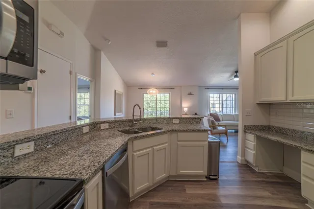 a kitchen with stainless steel appliances granite countertop a refrigerator and a stove