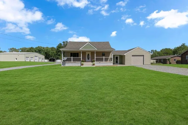 a front view of a house with a garden and yard