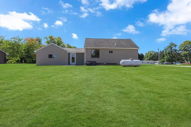 a view of an empty room with wooden floor and closet