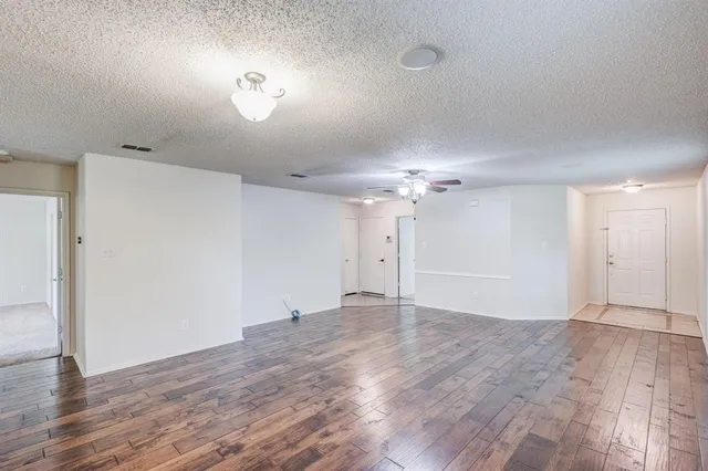 a view of an empty room with window and wooden floor