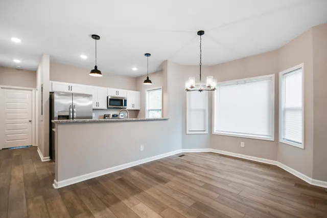 a view of a kitchen with wooden floor and windows