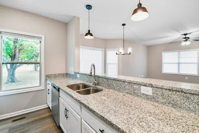 a kitchen with a granite countertop sink and window
