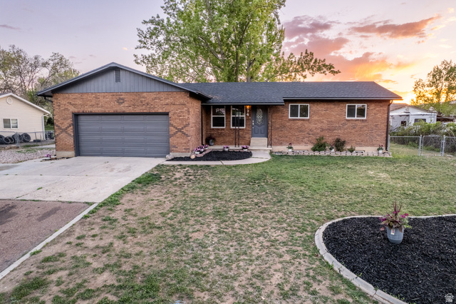 Brick exterior with dark gray siding and a matching garage door