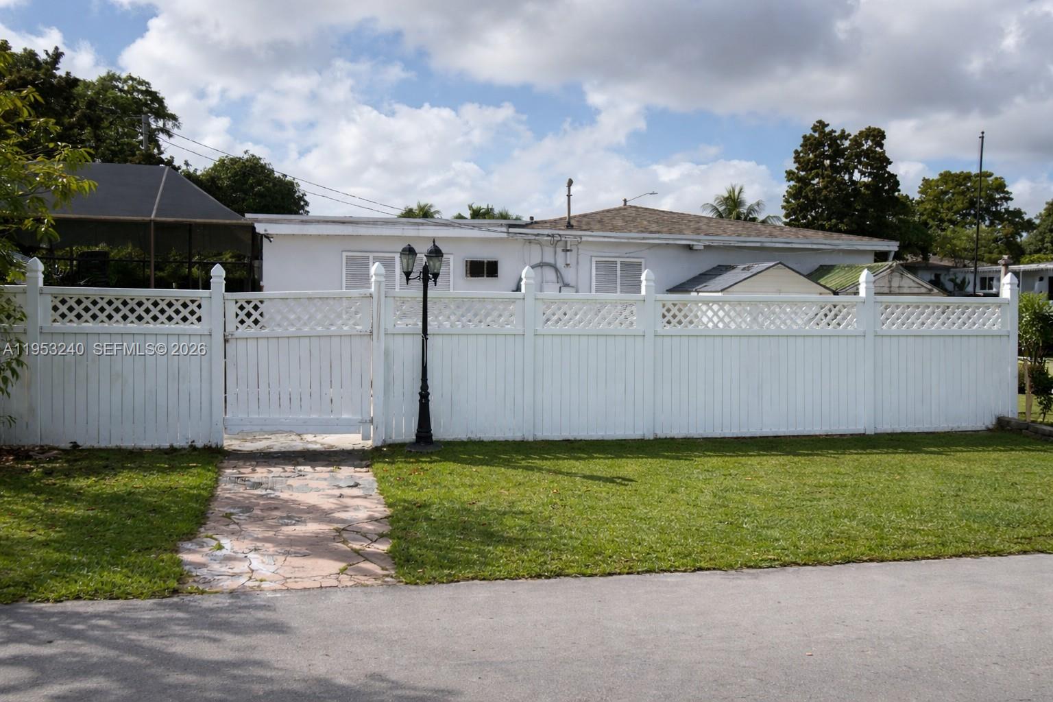 480 Northeast 109th Street Miami, FL 33161 - Photo 3 of 5 a front view of a house with a garden and yard