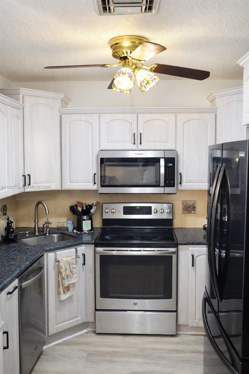 480 Northeast 109th Street Miami, FL 33161 - Photo 5 of 5 a kitchen with stainless steel appliances granite countertop a stove and a refrigerator