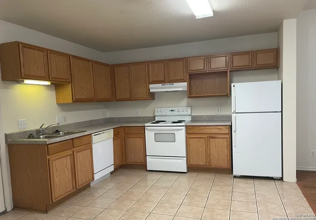 a kitchen with a stove sink and cabinets