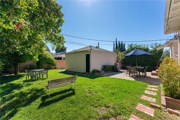 a view of a chair and table in backyard of the house