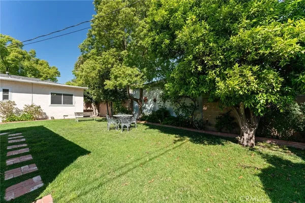 a view of a chair and table in backyard of the house
